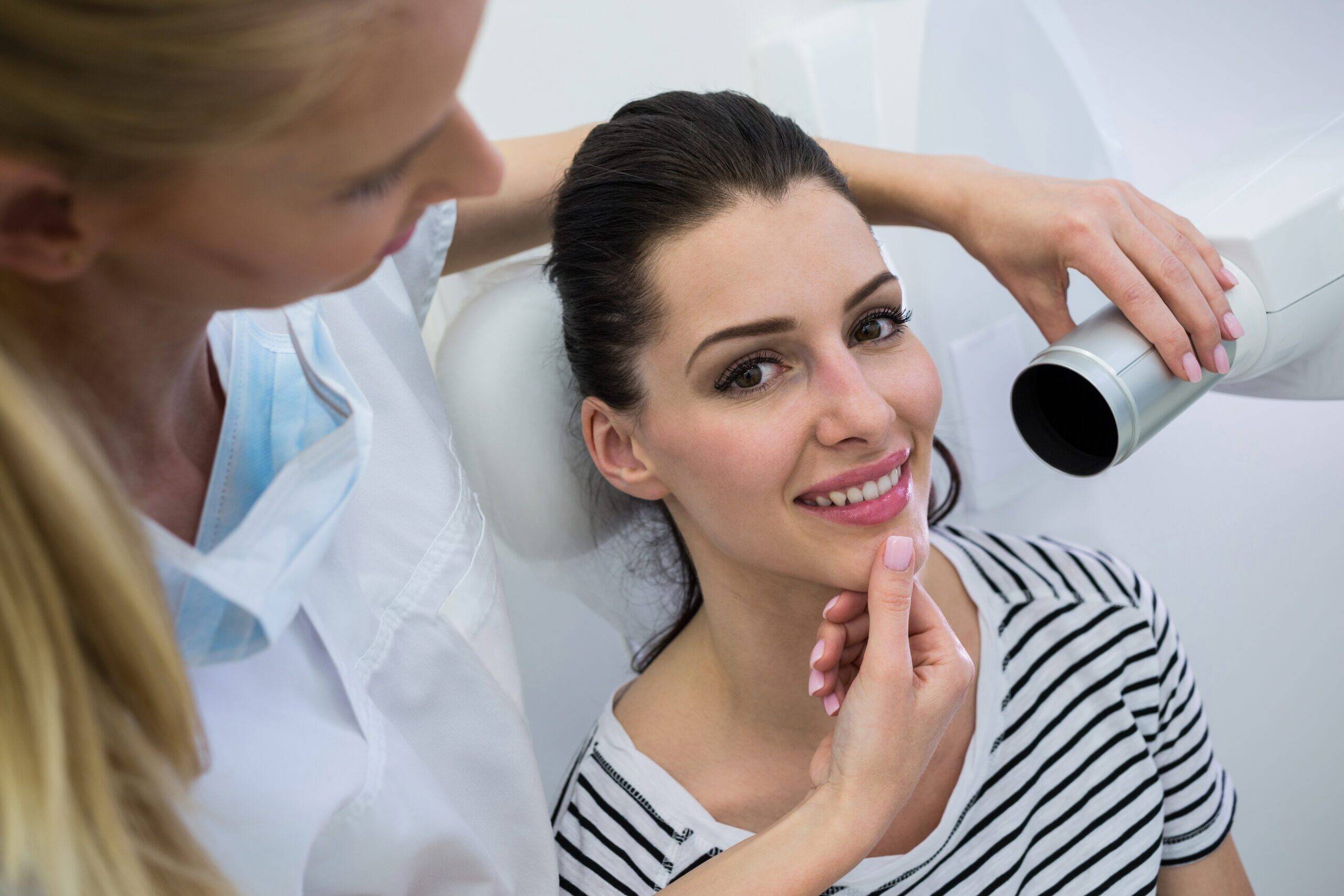 Dentist taking a female patients tooth x-ray in clinic