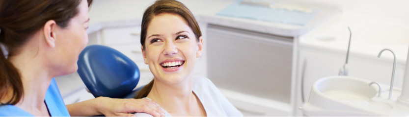 A Beautiful Young Woman Smiling And Looking At The Dentist