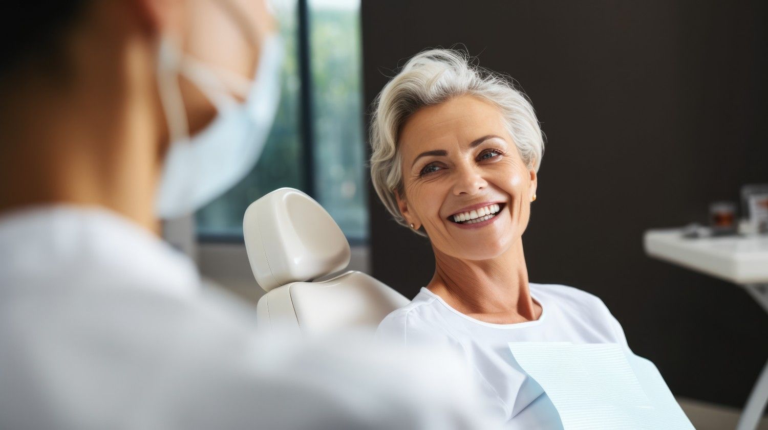 Woman smiling in dental chair during implant consultation.
