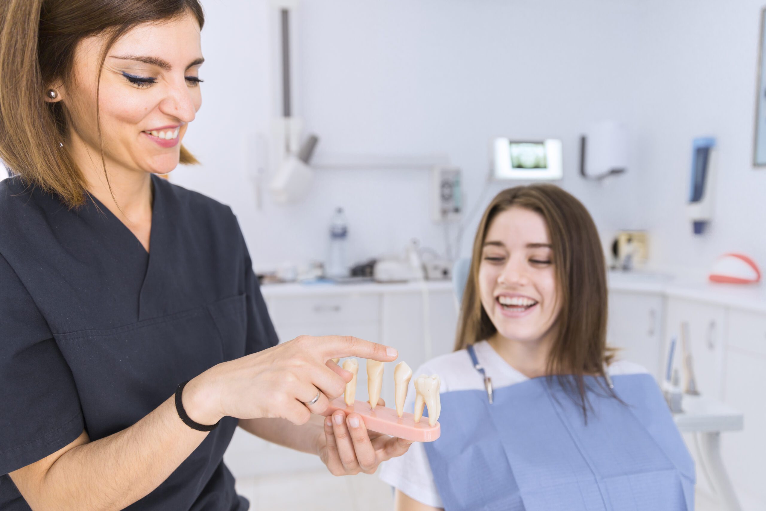 female-dentist-showing-teeth-model-female-patient-dental-clinic